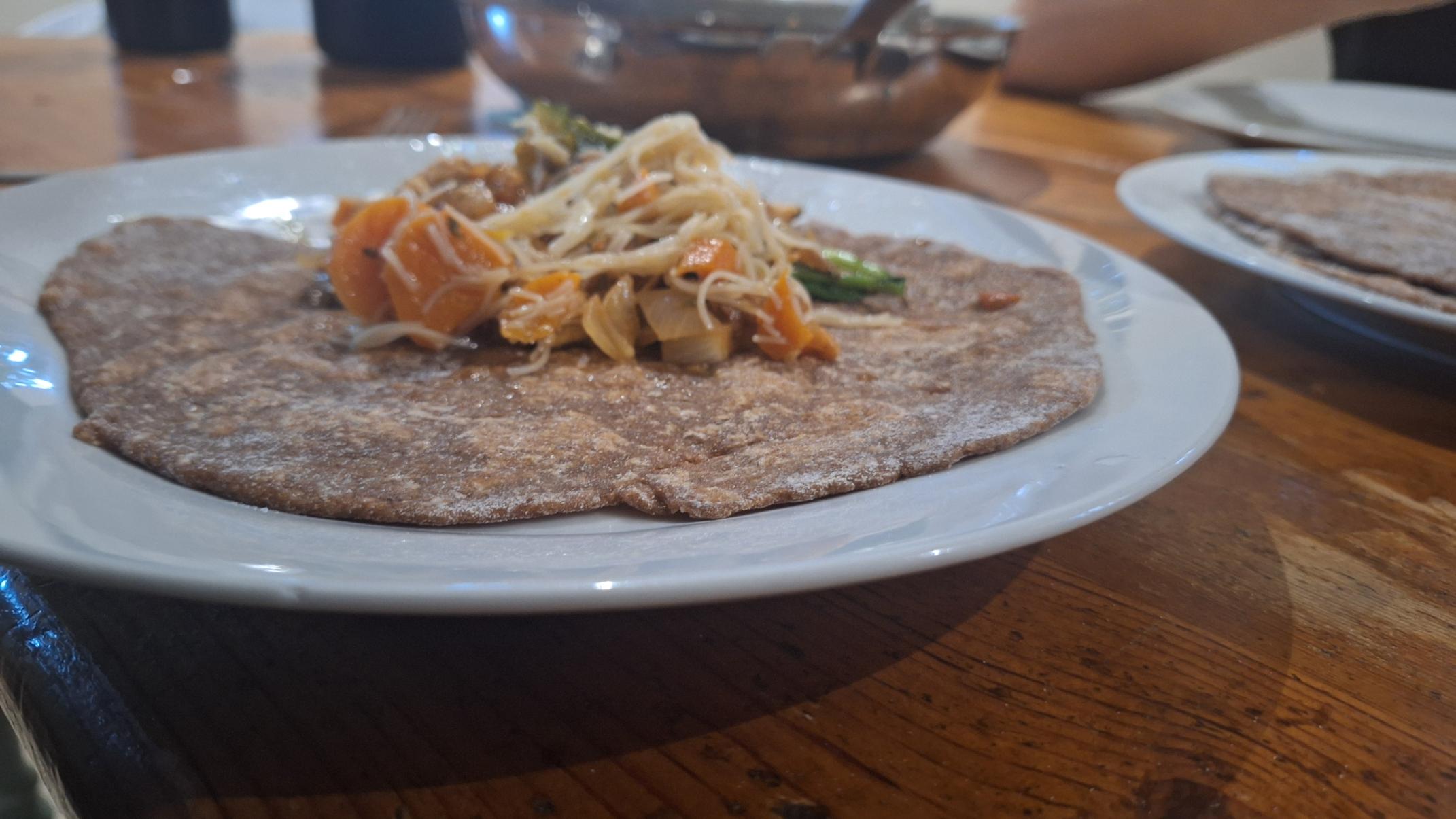 Vegetables sitting on top of a wrap as a serving suggestion.