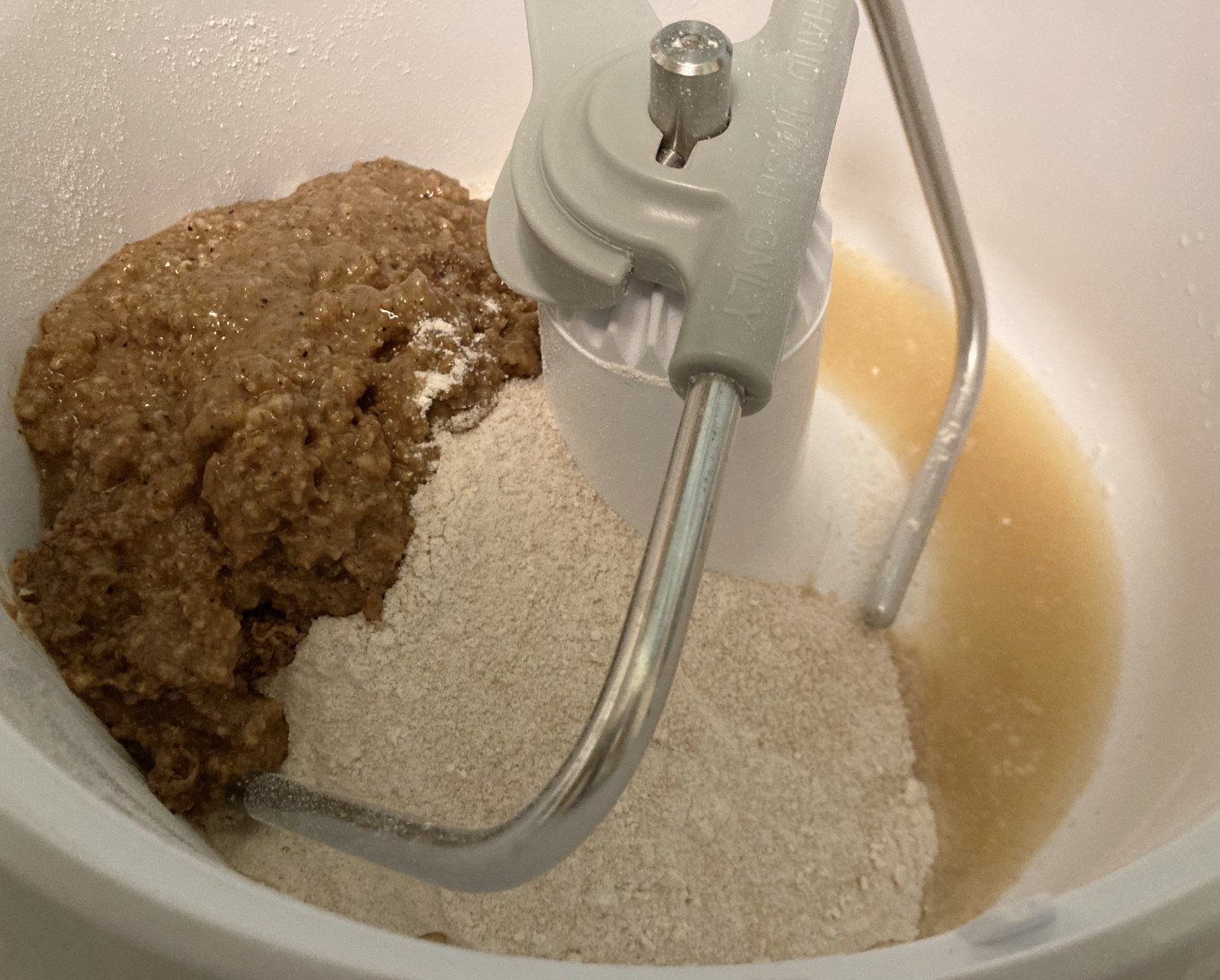 Mixer bowl with a dark mash, white whole wheat flour, and yellow pineapple juice, to show the darkness of the mash.