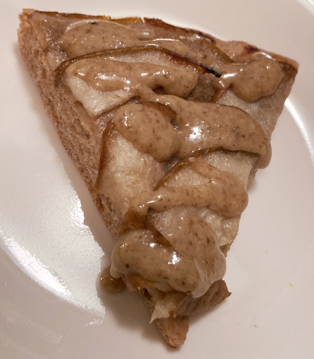 Slice of pear pizza topped with walnut butter.