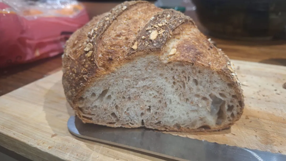 Sliced bread on bread board showing crumb. The breads shows swirls of white and wholewheat dough in cross section.