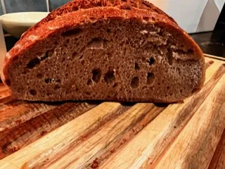 Sliced crusty loaf of bread with some rise